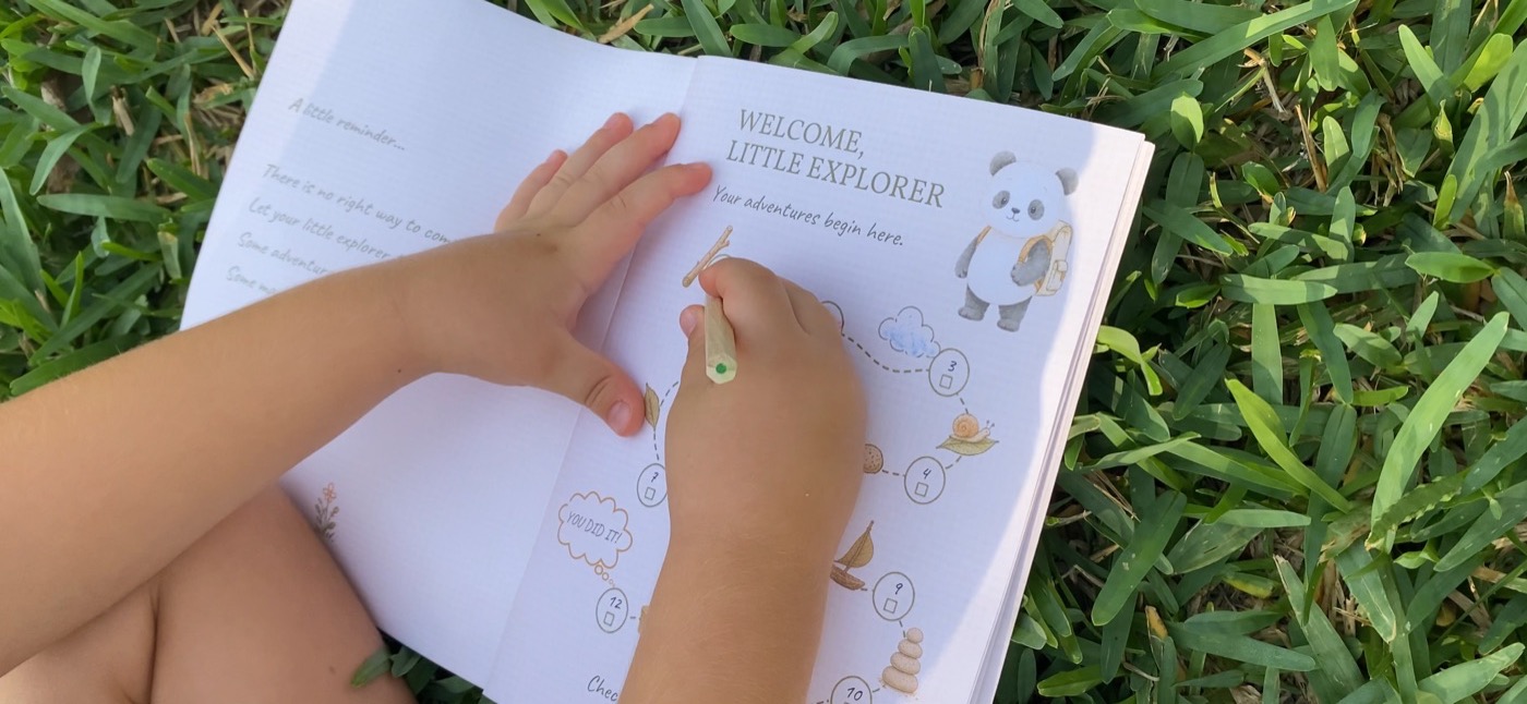 A child outdoors holding open the Explorer Passport